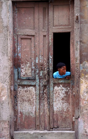 Niño mirando a través de la puerta en la Habana, Foto por James NG Boy looking out from a door, Havana. Photo by James NG
