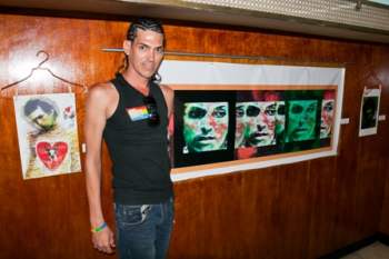 El artista Perea junto a una de las fotos de la exposición.